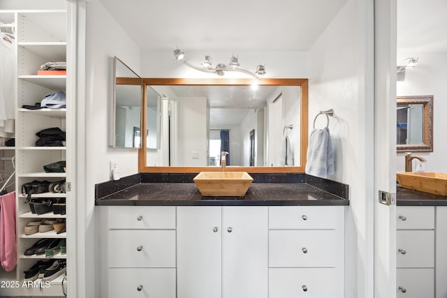 bathroom with a spacious closet and vanity