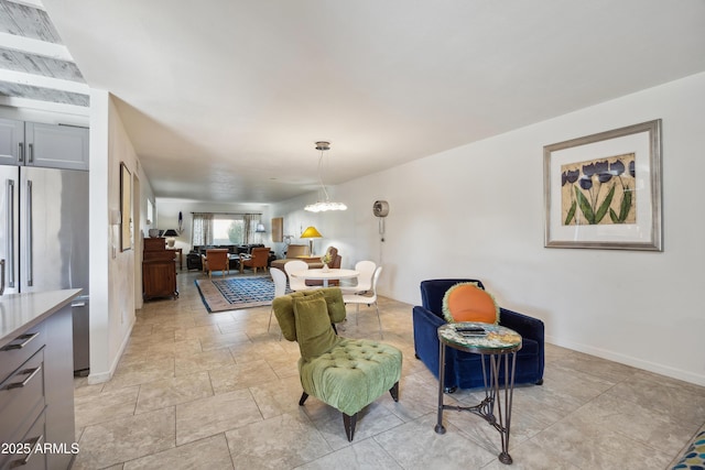 living room with baseboards and a notable chandelier