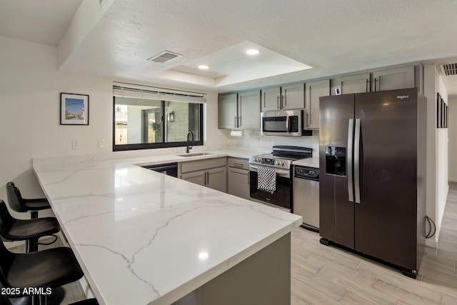 1540 E Glencove St, Mesa, AZ 85203 - kitchen featuring stainless steel appliances, a peninsula, gray cabinets, light stone counters, and a textured ceiling