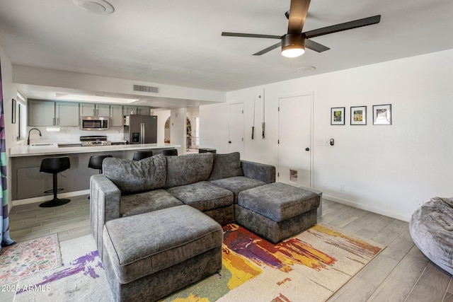1540 E Glencove St, Mesa, AZ 85203 - living room featuring light wood-type flooring, a ceiling fan, and baseboards