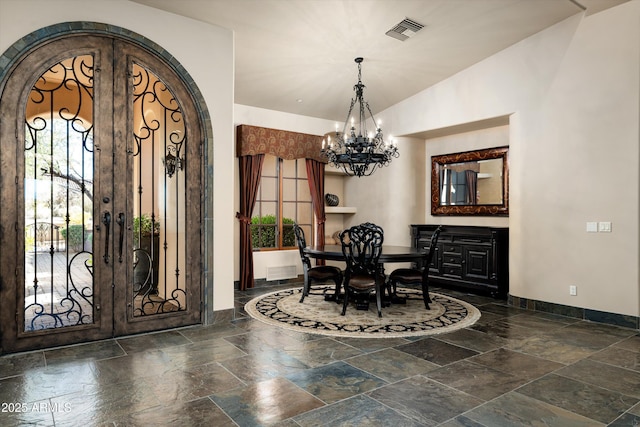 dining area featuring lofted ceiling, a chandelier, and french doors