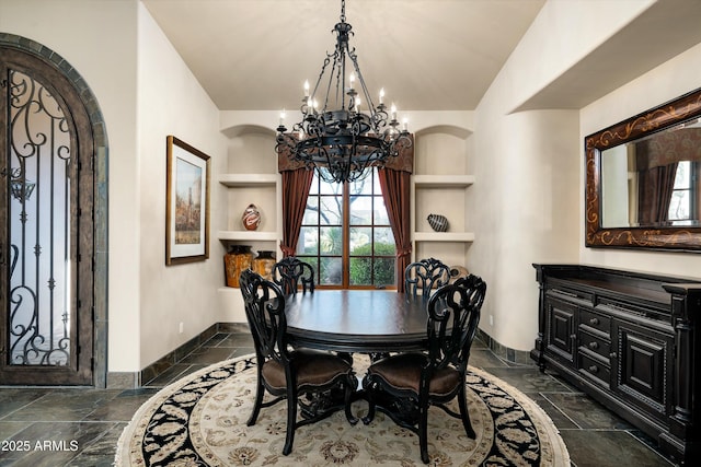 dining area with an inviting chandelier and built in shelves