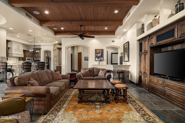 living room featuring beam ceiling, ceiling fan with notable chandelier, and wooden ceiling