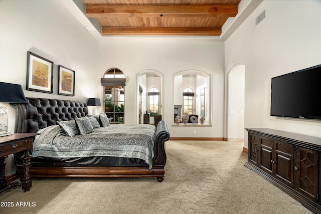 carpeted bedroom with a towering ceiling, wooden ceiling, and beam ceiling