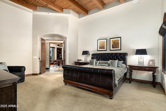 carpeted bedroom with a towering ceiling, wooden ceiling, and beam ceiling