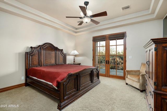 bedroom featuring light colored carpet, a raised ceiling, and access to outside