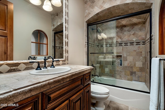 full bathroom with vanity, enclosed tub / shower combo, and toilet