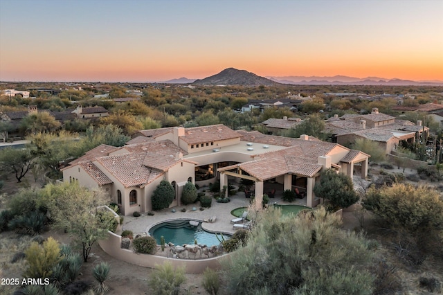 aerial view at dusk featuring a mountain view