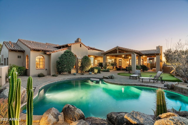 pool at dusk with a patio