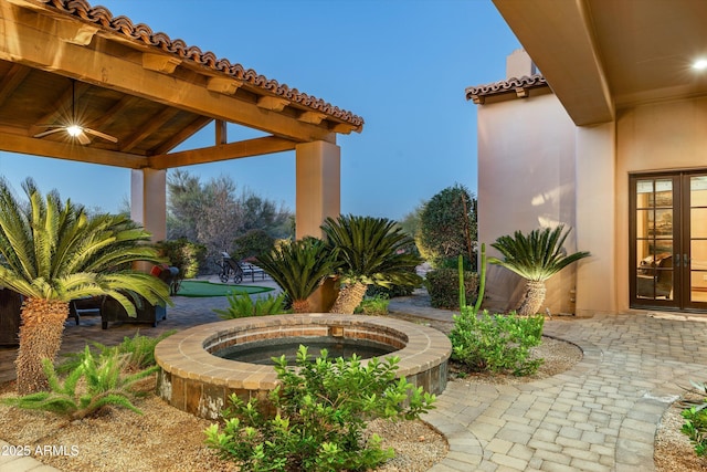 exterior space featuring a gazebo, an in ground hot tub, and french doors