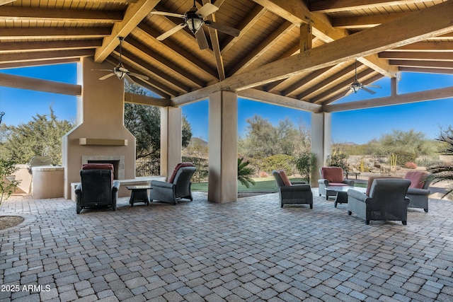 view of patio / terrace featuring a gazebo, a large fireplace, an outdoor kitchen, and ceiling fan