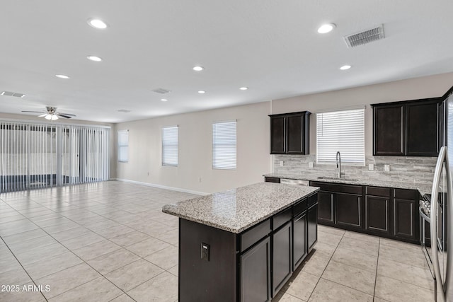29402 W Mitchell Ave, Buckeye, AZ 85396 - kitchen with a sink, light tile patterned floors, tasteful backsplash, healthy amount of natural light, and recessed lighting