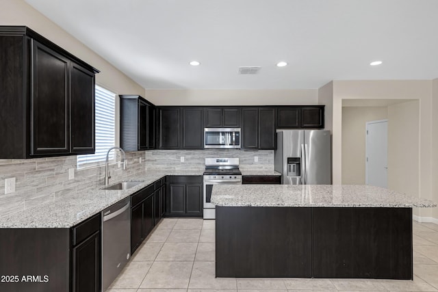 29402 W Mitchell Ave, Buckeye, AZ 85396 - kitchen with appliances with stainless steel finishes, a sink, dark cabinetry, a center island, and recessed lighting