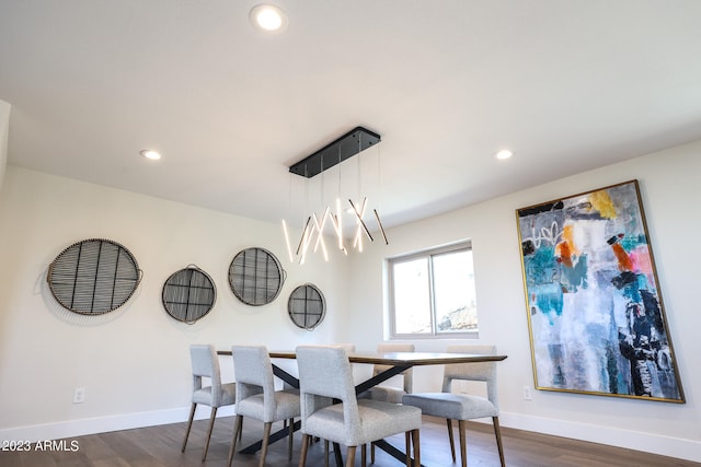 dining area featuring dark hardwood / wood-style floors and an inviting chandelier