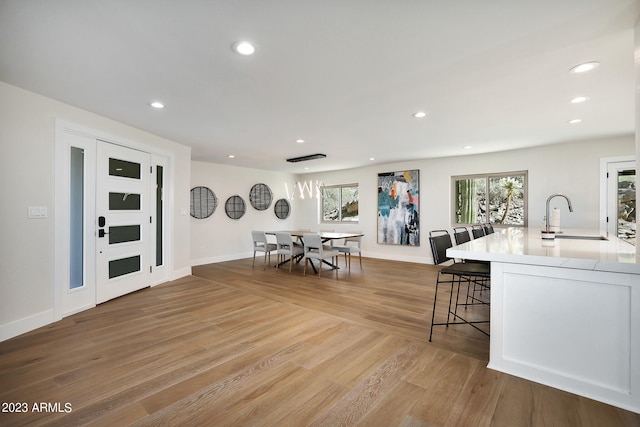 interior space featuring a breakfast bar, sink, and hardwood / wood-style flooring