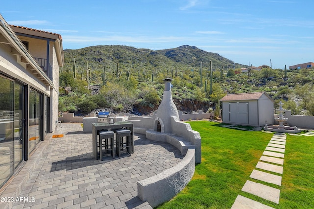 exterior space featuring a patio area, a mountain view, and a storage shed