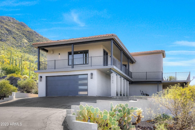 view of front of home featuring a balcony, a mountain view, and a garage