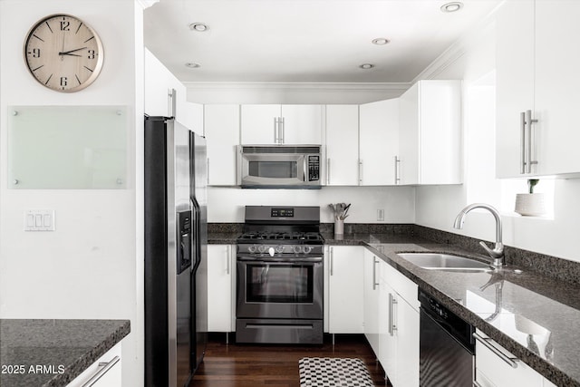 kitchen featuring a sink, stainless steel appliances, dark stone counters, dark wood finished floors, and white cabinetry
