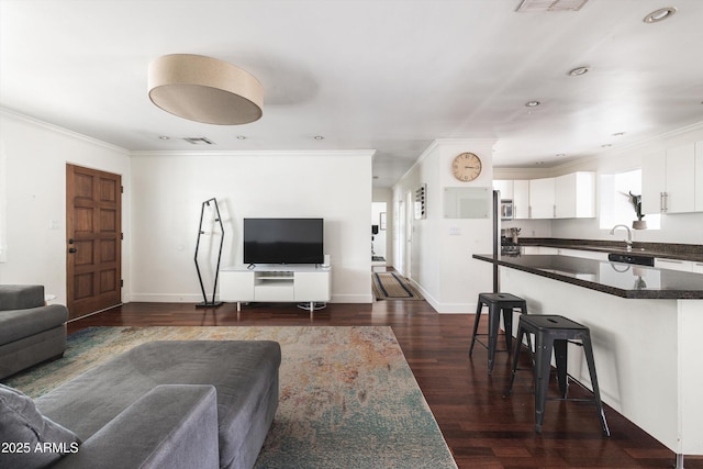 living area featuring baseboards, crown molding, visible vents, and dark wood-type flooring