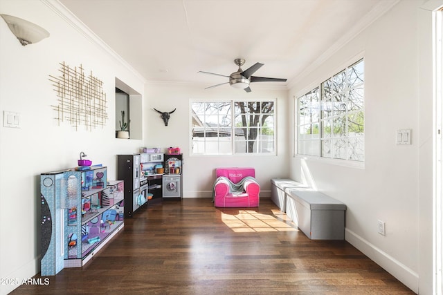 game room with a ceiling fan, ornamental molding, baseboards, and wood finished floors