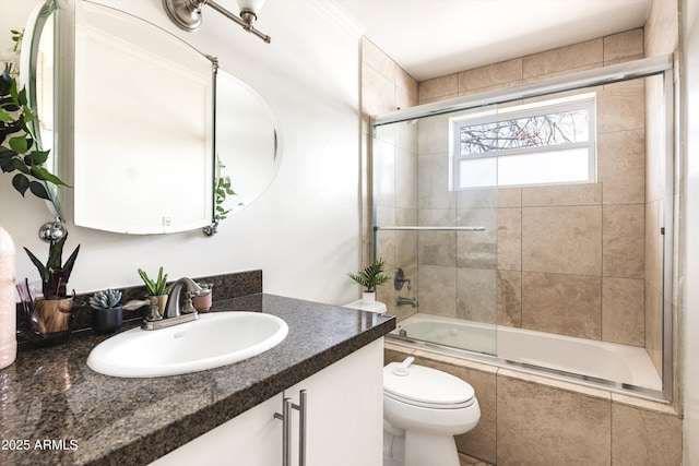 bathroom with tiled shower / bath combo, vanity, and toilet