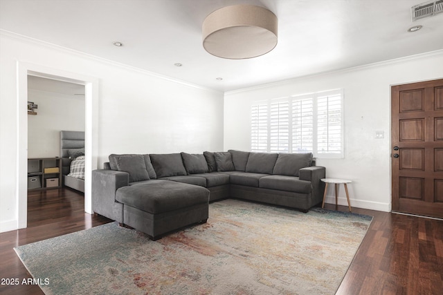 living area featuring visible vents, wood finished floors, baseboards, and ornamental molding