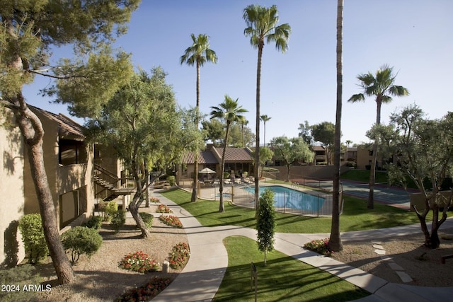 view of home's community with a pool and a lawn