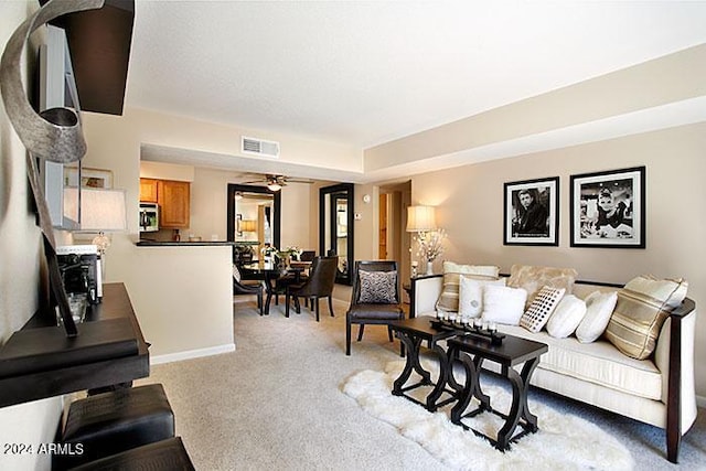 living room featuring light colored carpet and ceiling fan