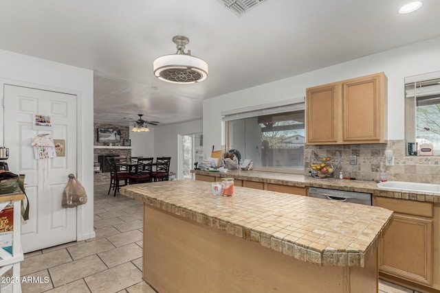 kitchen featuring visible vents, light tile patterned floors, a sink, stainless steel dishwasher, and decorative backsplash