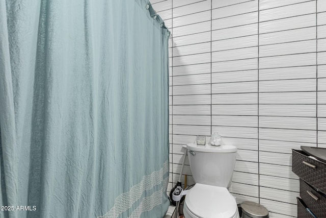 full bathroom with a shower with shower curtain and toilet