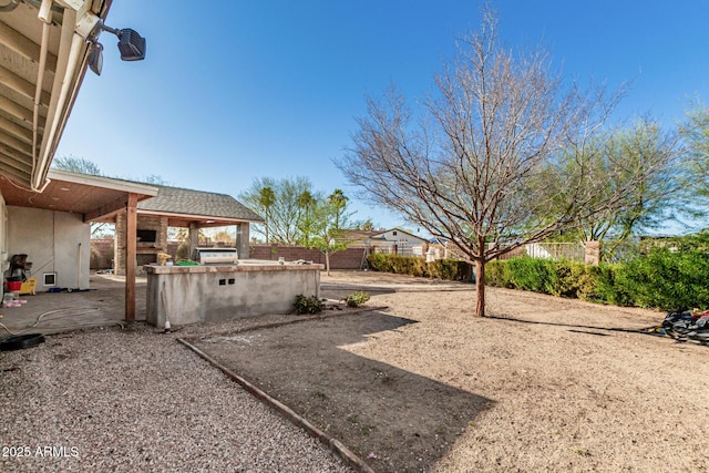 view of yard with fence, a patio, and area for grilling