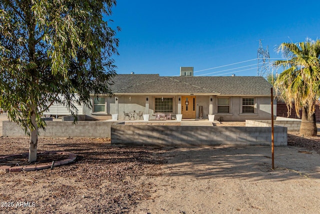 ranch-style house with roof with shingles, a patio, and stucco siding
