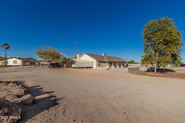ranch-style home featuring uncovered parking and fence