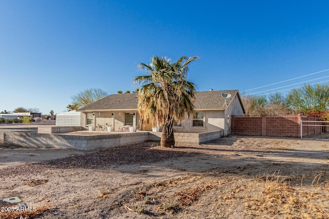 view of front of property with a patio area and fence