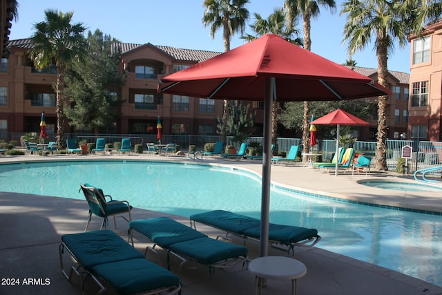 view of swimming pool with a hot tub