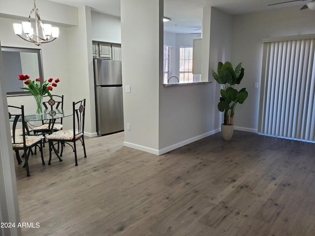 dining room with ceiling fan with notable chandelier and hardwood / wood-style flooring