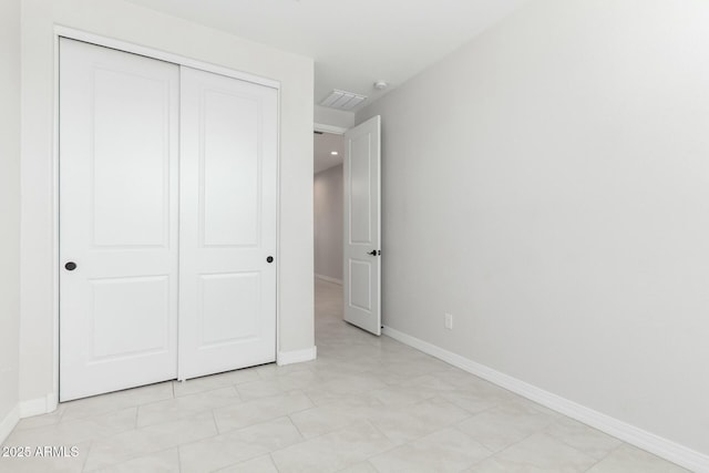 unfurnished bedroom with a closet and baseboards