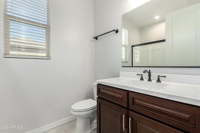 full bathroom featuring a shower with door, toilet, vanity, baseboards, and tile patterned floors