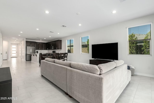 living room featuring plenty of natural light, visible vents, and recessed lighting