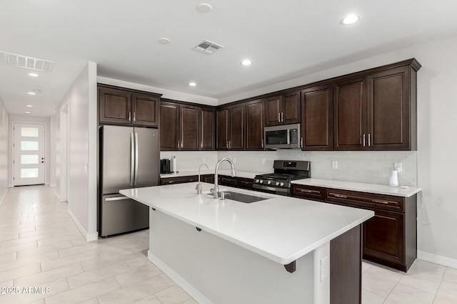 kitchen with visible vents, appliances with stainless steel finishes, light countertops, and a sink