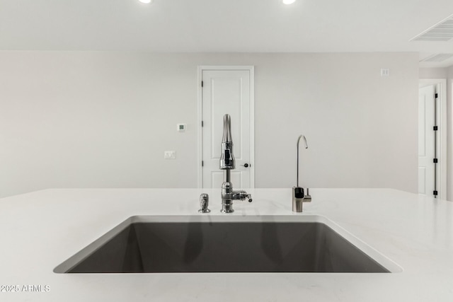 details featuring recessed lighting, light countertops, a sink, and visible vents