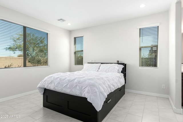 bedroom featuring multiple windows, visible vents, and baseboards