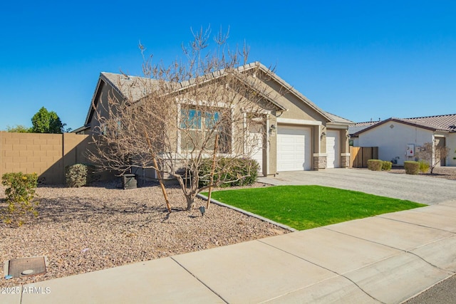 view of front of home with driveway, stucco siding, an attached garage, fence, and a front yard