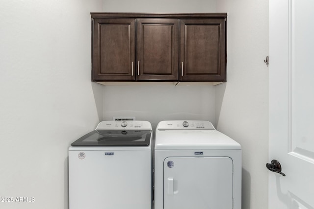 washroom featuring washing machine and dryer and cabinet space