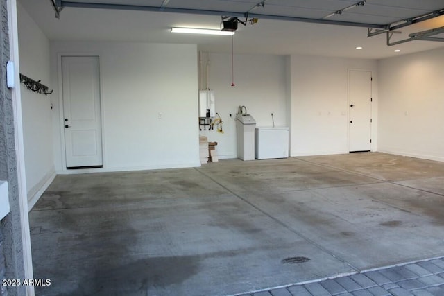 garage featuring baseboards, washer and dryer, and a garage door opener