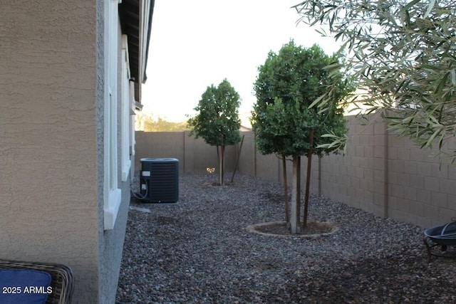 view of yard featuring a fenced backyard and central AC