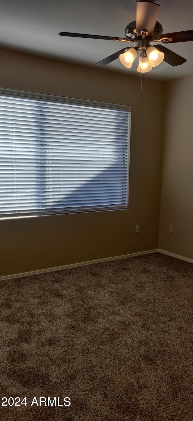 unfurnished room featuring ceiling fan and carpet flooring