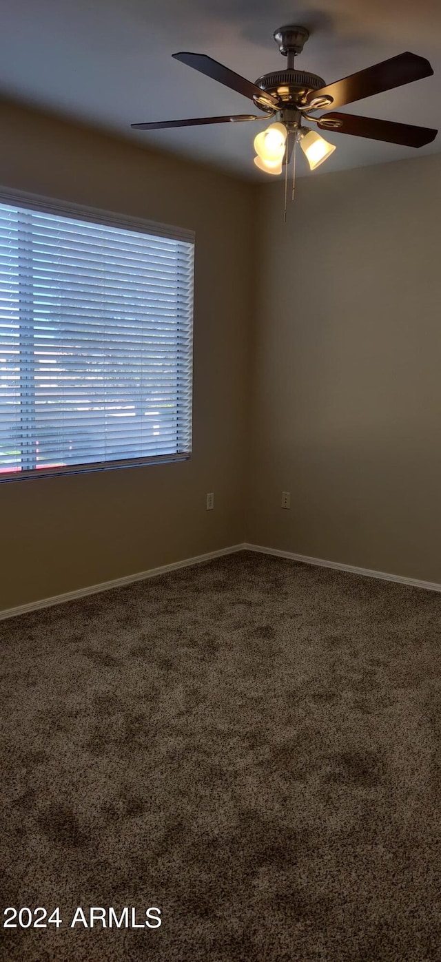 carpeted empty room featuring ceiling fan