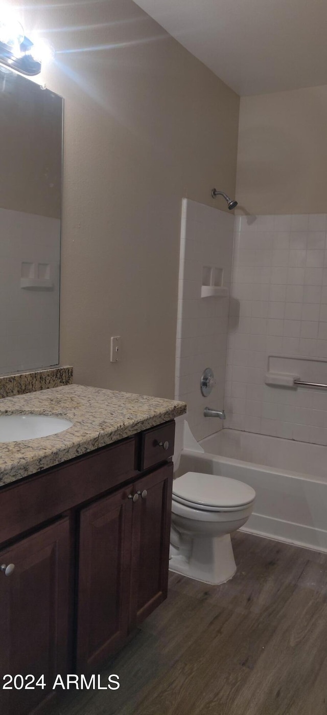 full bathroom with wood-type flooring, vanity, toilet, and tiled shower / bath