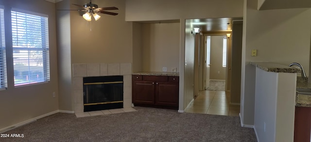 unfurnished living room featuring ceiling fan, light colored carpet, and a fireplace